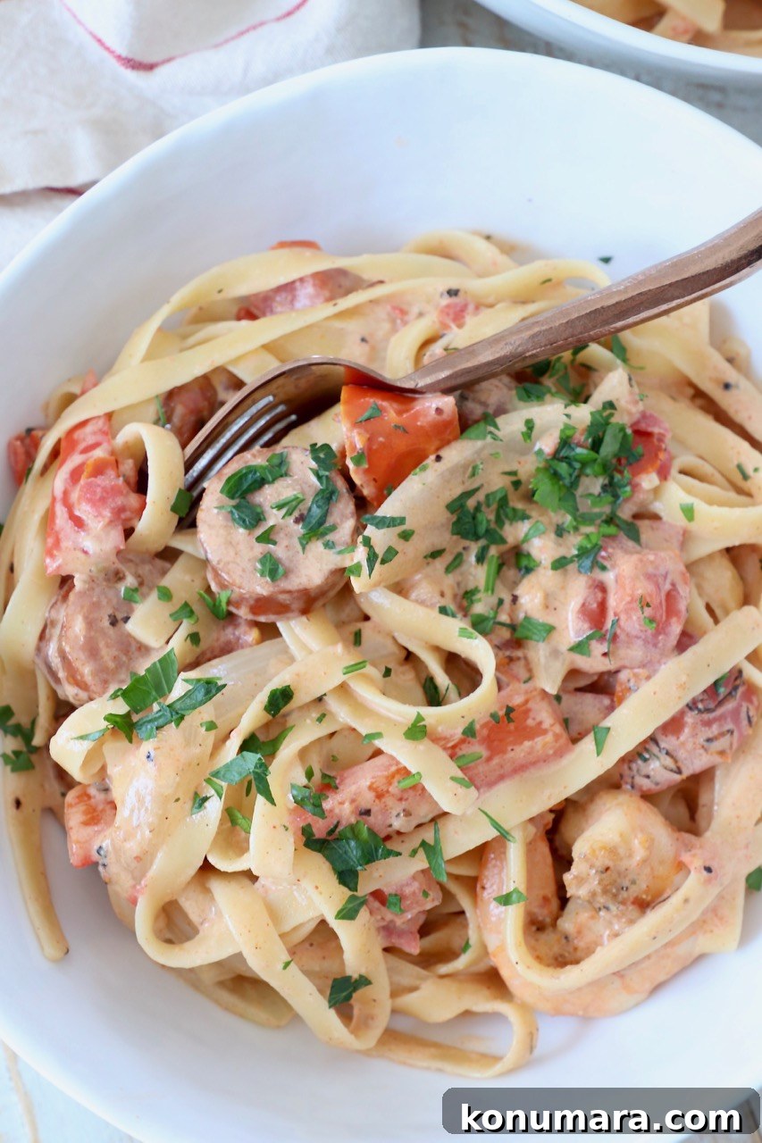 Creamy Cajun Shrimp Pasta with Andouille Sausage 9 cooked cajun shrimp pasta with sausage in bowl with spoon