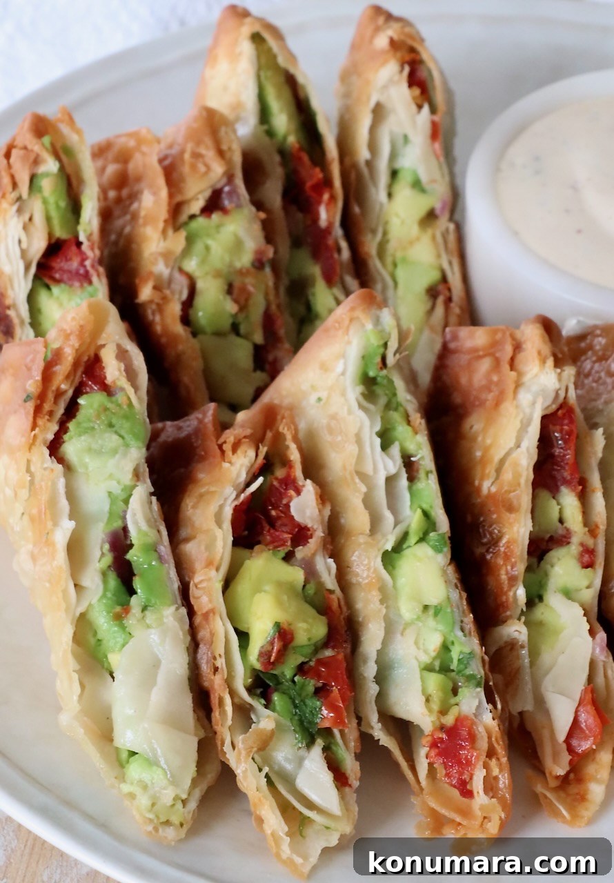 avocado egg rolls sliced in half on plate