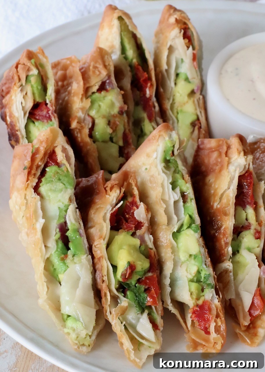 avocado egg rolls sliced in half on plate
