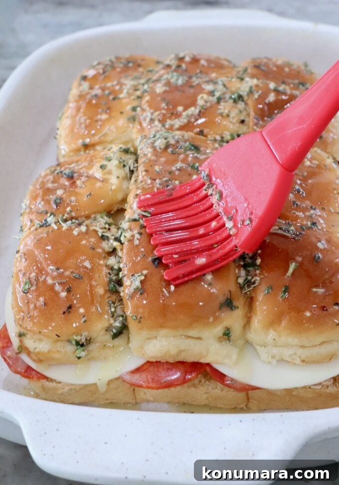 Italian sub sliders in casserole dish brushed with herb butter