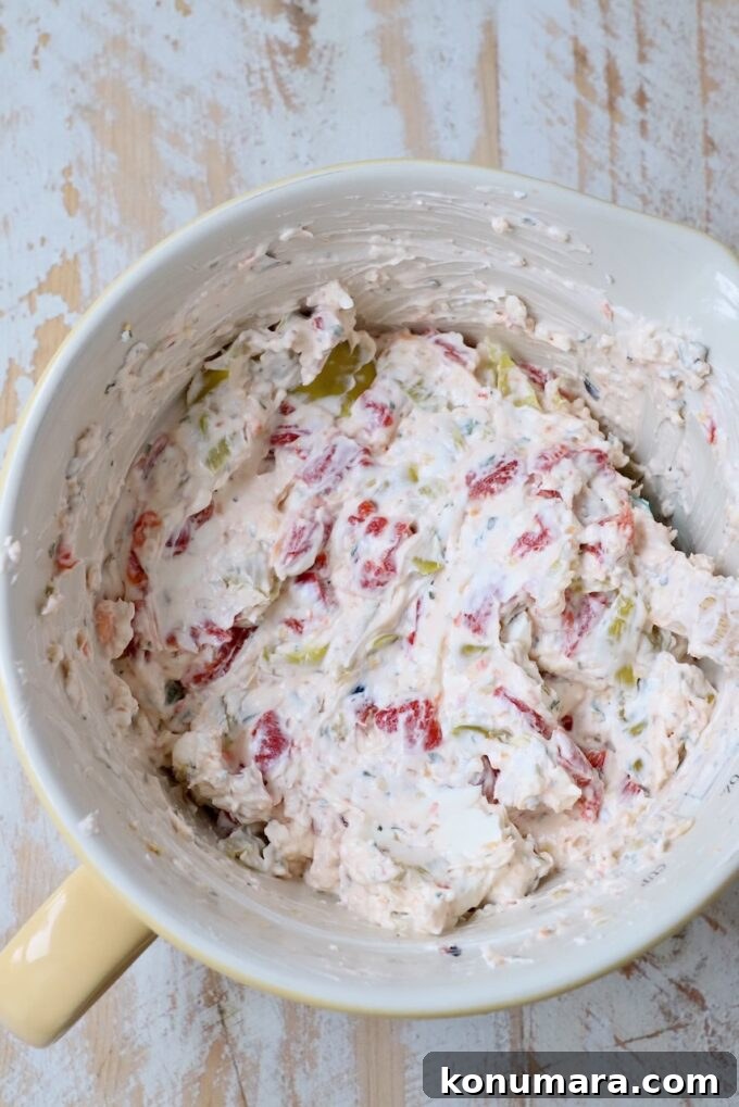 cream cheese mixed with roasted red peppers, pepperoncinis and Italian seasoning in bowl