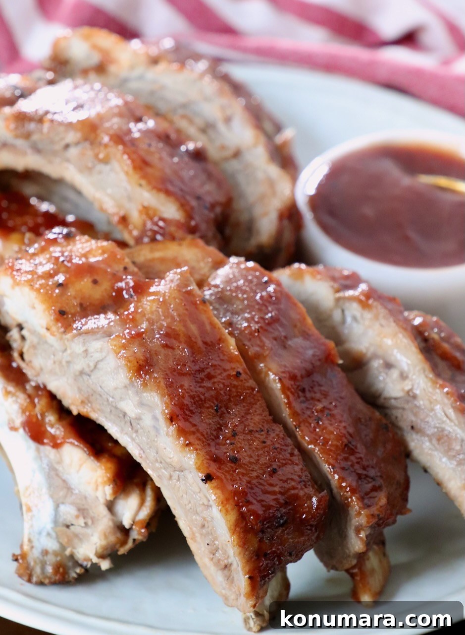 Tender Instant Pot Ribs in 45 Minutes 9 cooked baby back ribs brushed with bbq sauce on plate