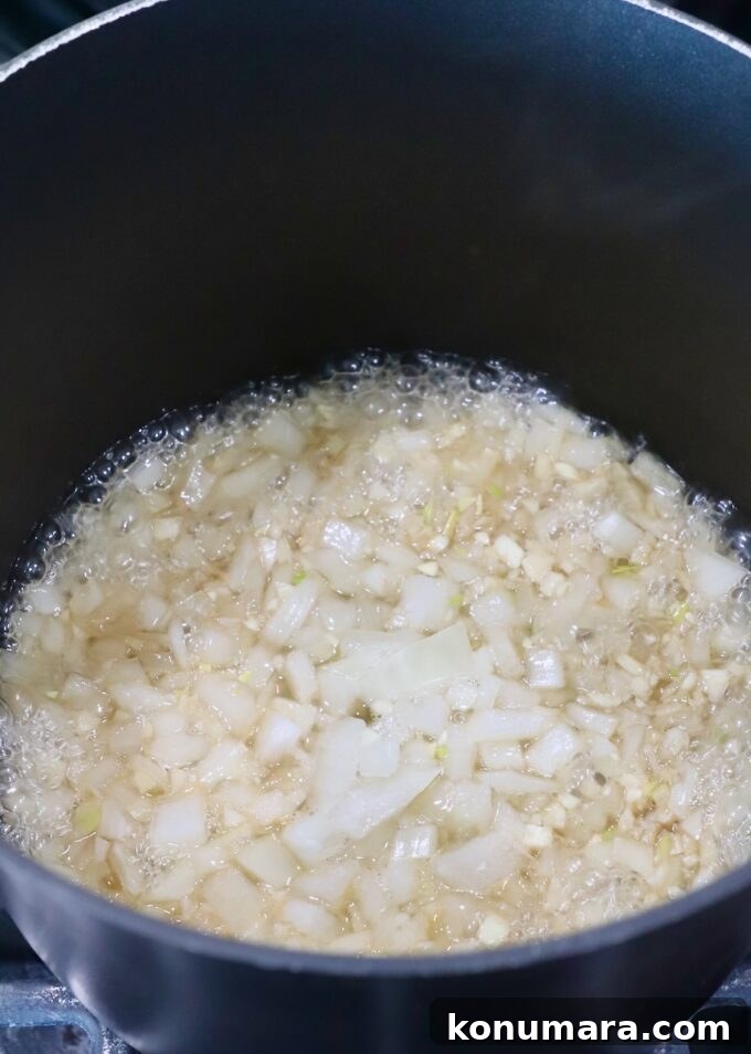 Jack Daniel's BBQ Sauce Recipe: Smoky and Tangy 4 diced onions simmering in whiskey in a saucepan on the stove