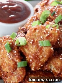 cooked chicken strips tossed in bbq sauce on plate topped with diced green onions