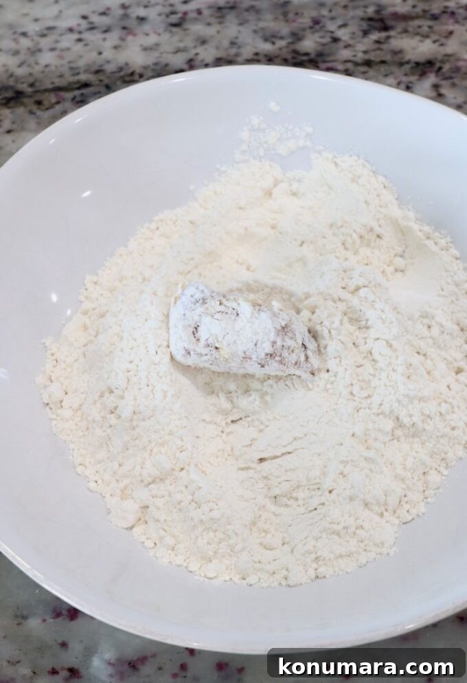 Jack Daniel's BBQ Chicken Strips Recipe 7 piece of chicken covered in flour in bowl