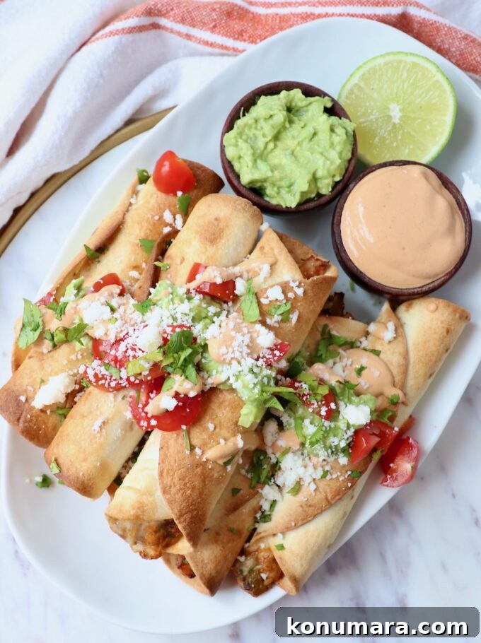 How to Make Smoky Chipotle Sauce for Tacos, Burgers and Dips 7 taquitos stacked up on plate with diced tomatoes and cotija cheese on top