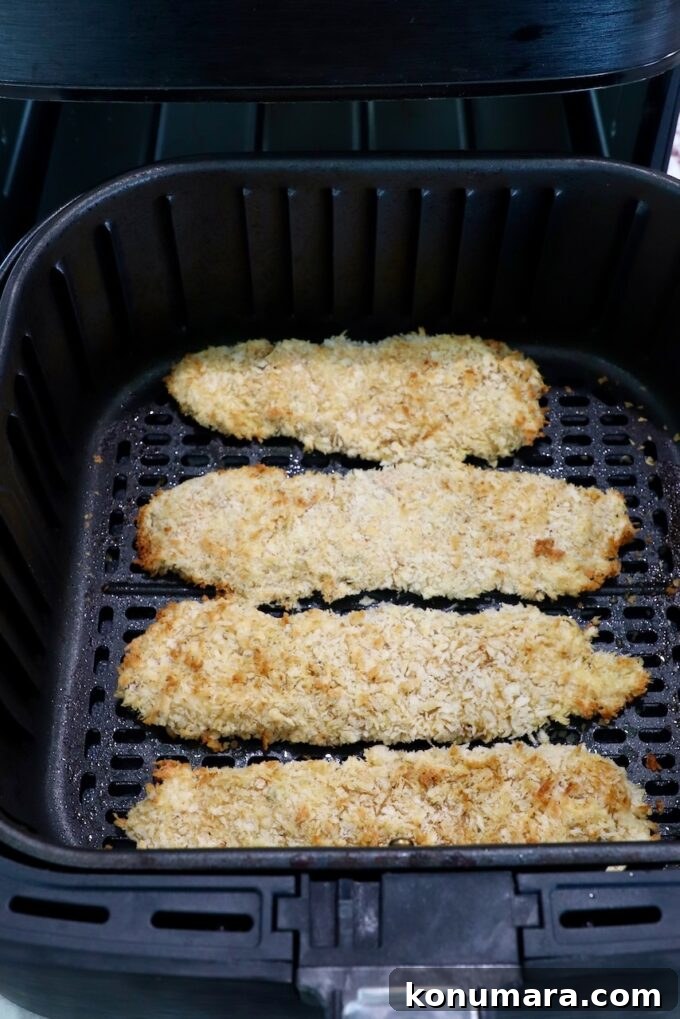 Crispy Air Fryer Chicken Tenders Recipe 11 cooked breaded chicken tenders in an air fryer basket