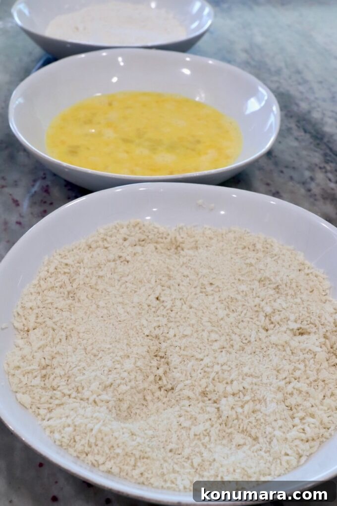 Crispy Air Fryer Chicken Tenders Recipe 4 three bowls with breadcrumbs in one bowl, whisked eggs in another bowl and flour in the third bowl