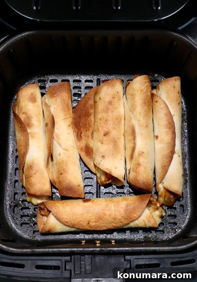 Crispy Air Fryer Taquitos Recipe 11 cooked taquitos in an air fryer basket