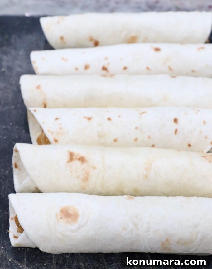 Crispy Air Fryer Taquitos Recipe 9 prepared taquitos, uncooked, on cutting board