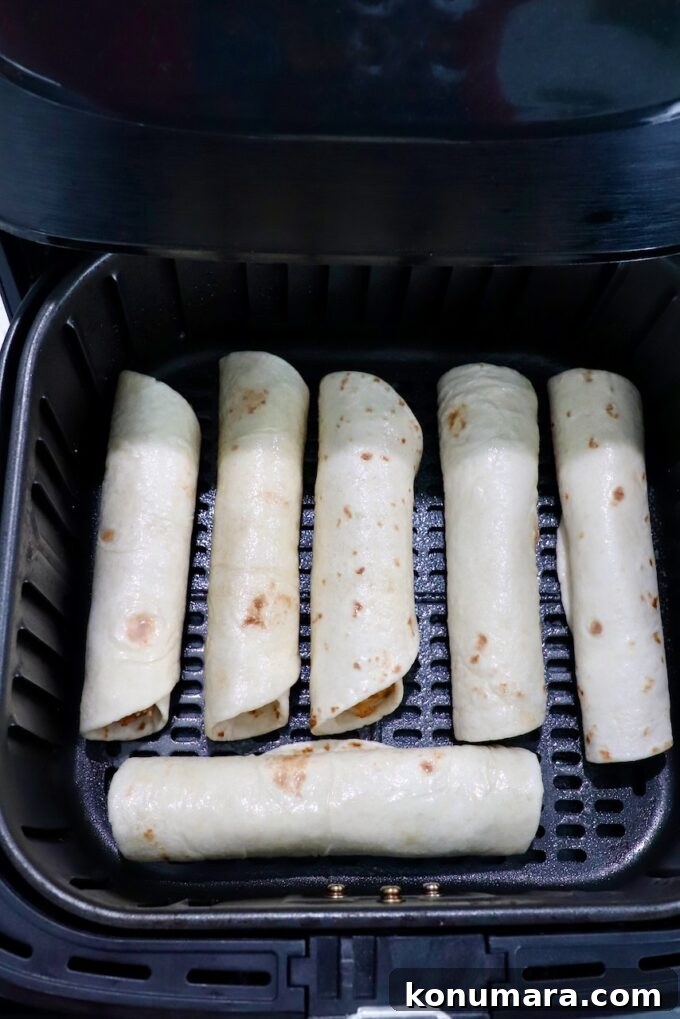 Crispy Air Fryer Taquitos Recipe 10 uncooked taquitos in an air fryer basket