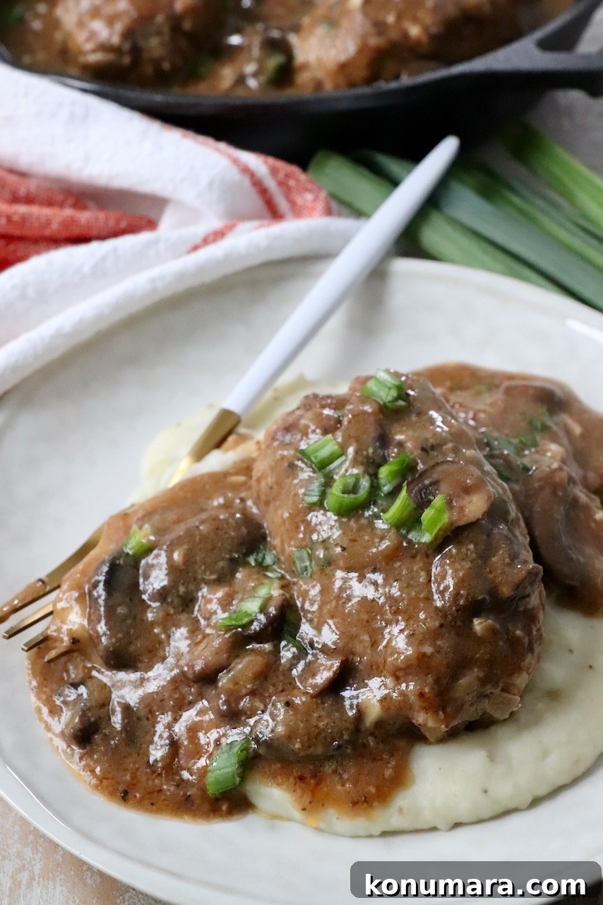 salisbury steak on plate with mushroom gravy and mashed potatoes