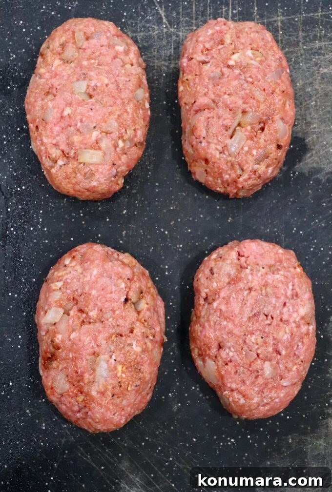 four beef patties on cutting board