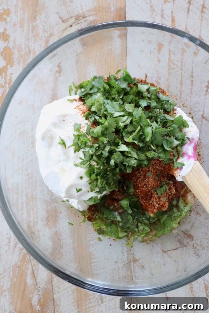 sour cream, cilantro and spices in small glass bowl