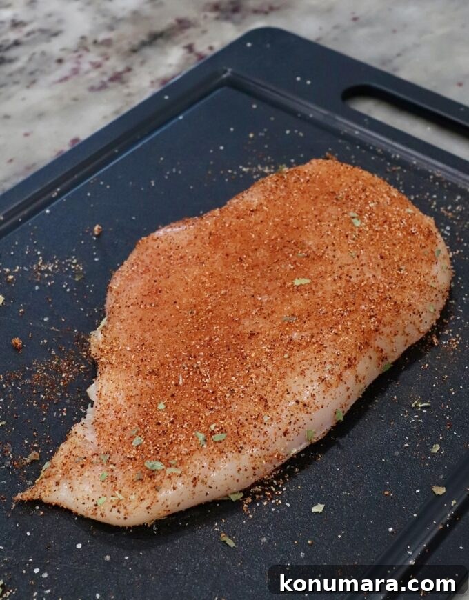 seasoned chicken breast on cutting board