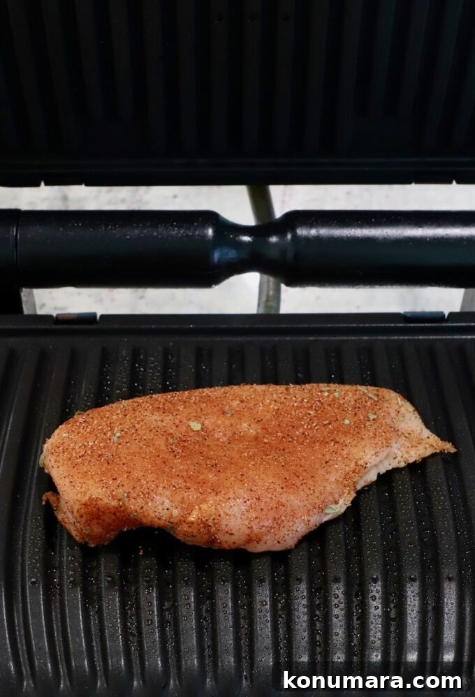 uncooked seasoned chicken breast in grill