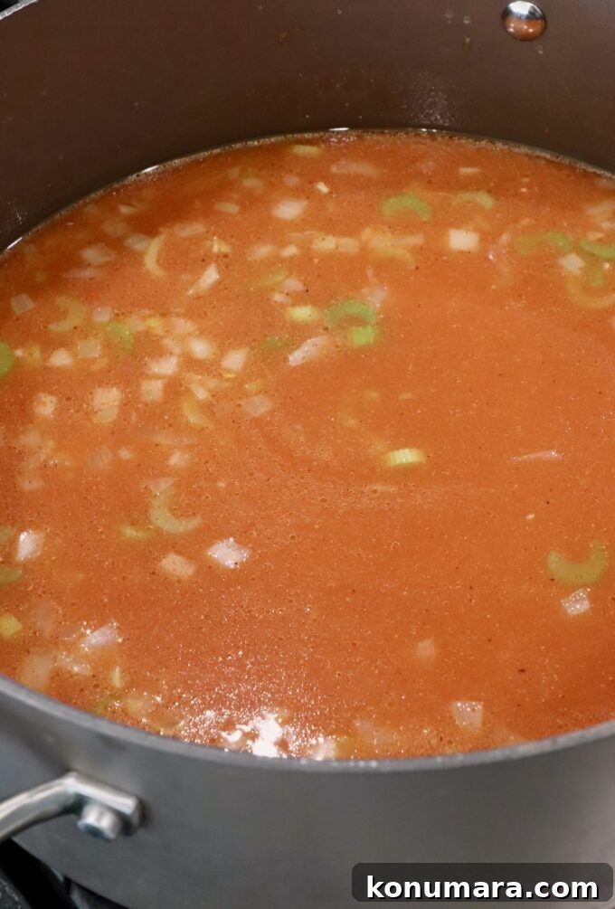 Creamy Buffalo Chicken Soup Recipe 5 seasoned chicken broth with diced veggies in pot