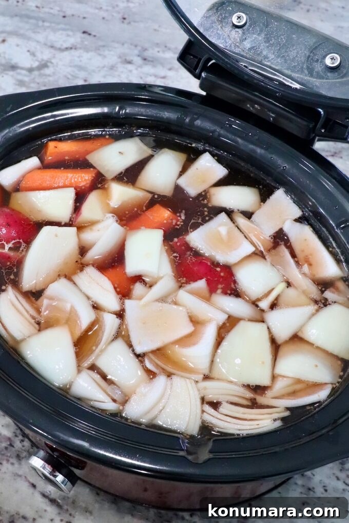 vegetables in crock pot with beef broth and brisket