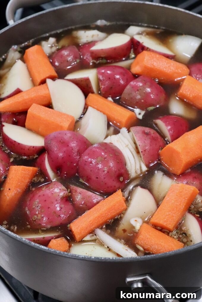 carrots, onions and red potatoes in beef broth in dutch oven