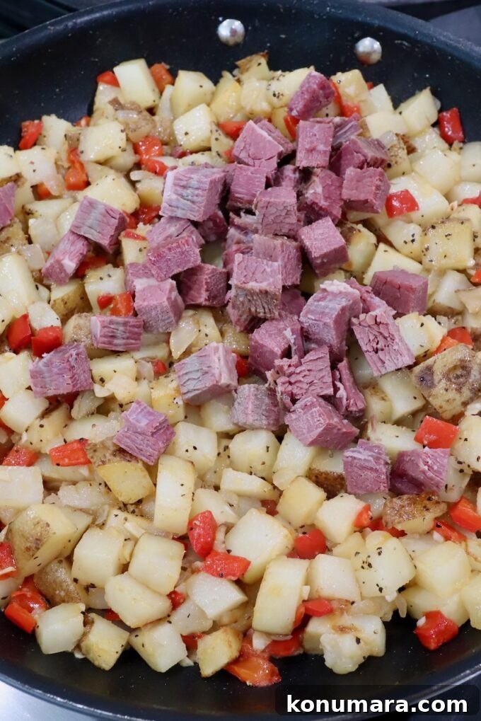 Corned Beef Hash with Crispy Potatoes 5 diced corned beef with diced potatoes, onions and peppers in a large skillet
