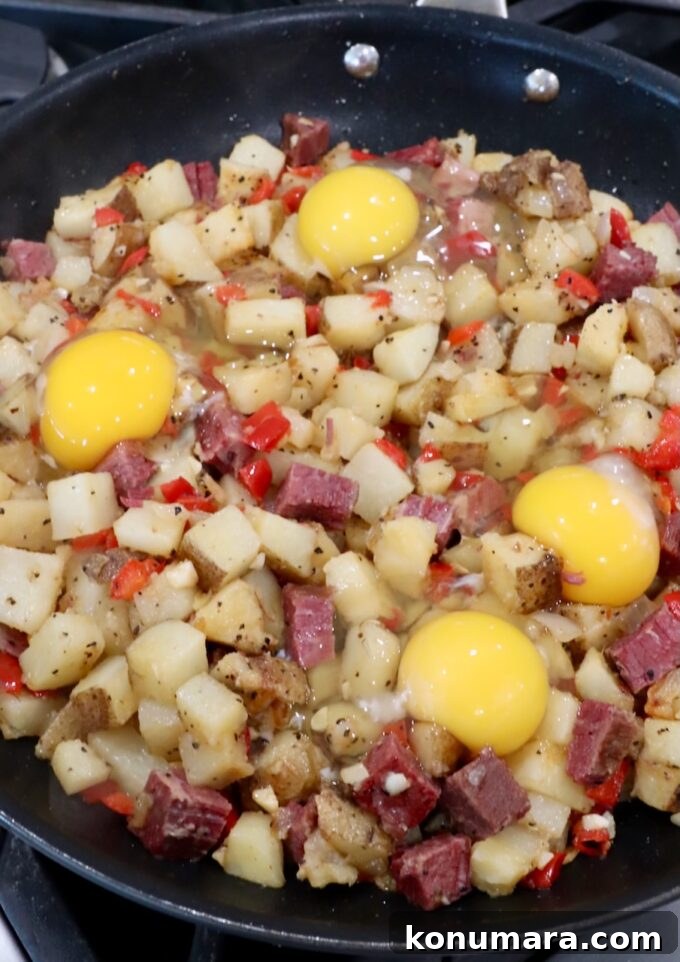 Corned Beef Hash with Crispy Potatoes 6 raw eggs, cracked on top of corned beef hash in a large skillet