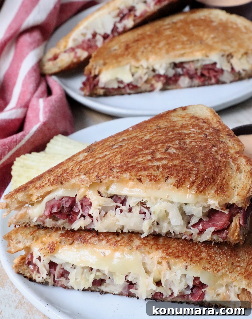 reuben sandwich sliced in half on plate
