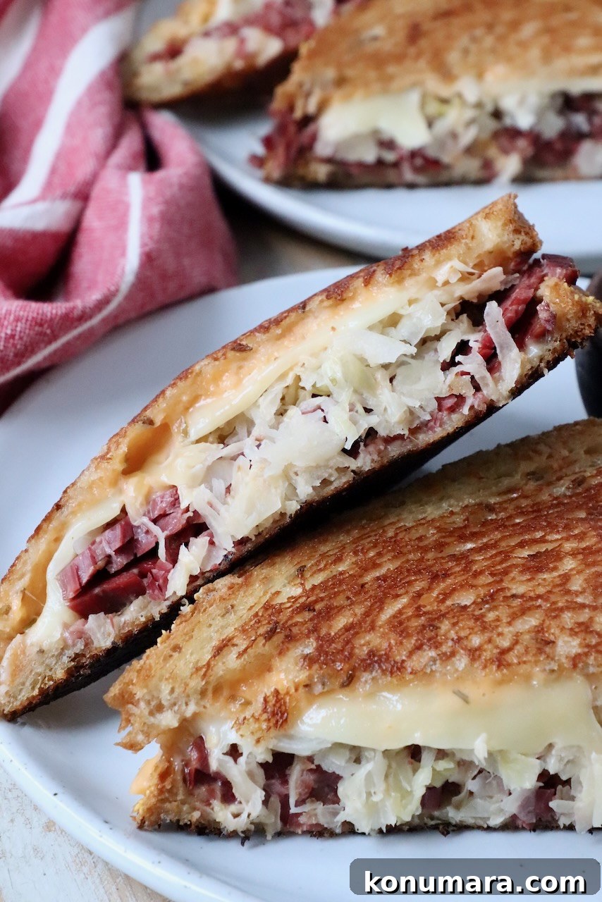 reuben sandwich sliced in half on plate