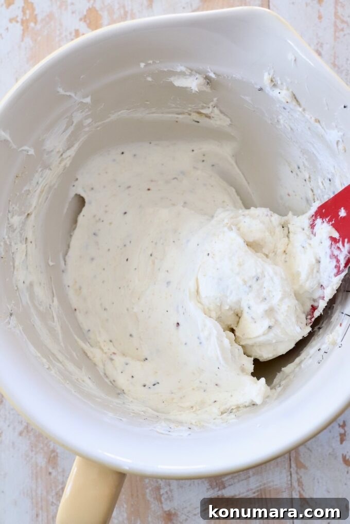 seasoned cream cheese in bowl with spatula