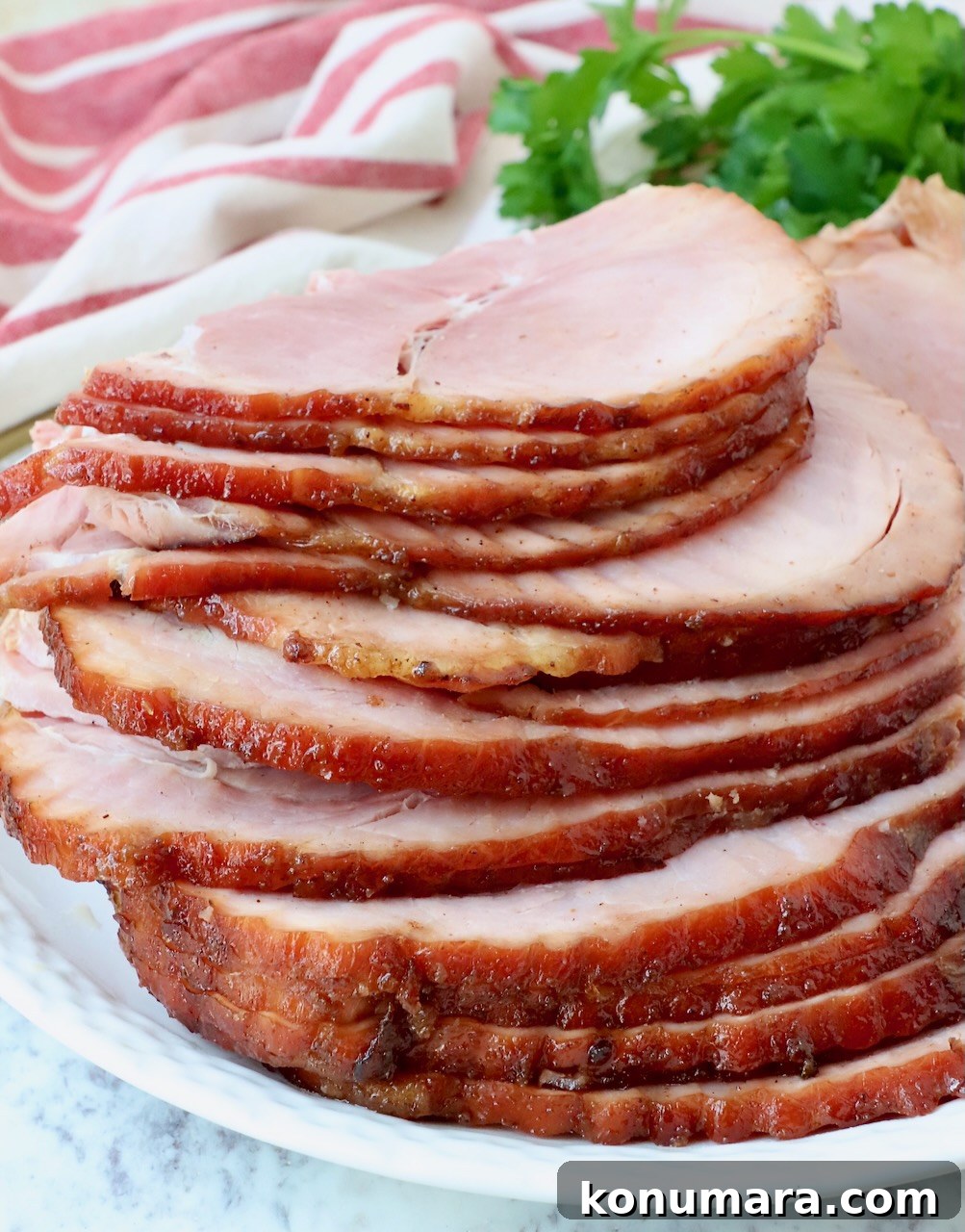 Honey-Baked Ham Recipe with Brown Sugar Glaze 11 sliced ham stacked up on a plate