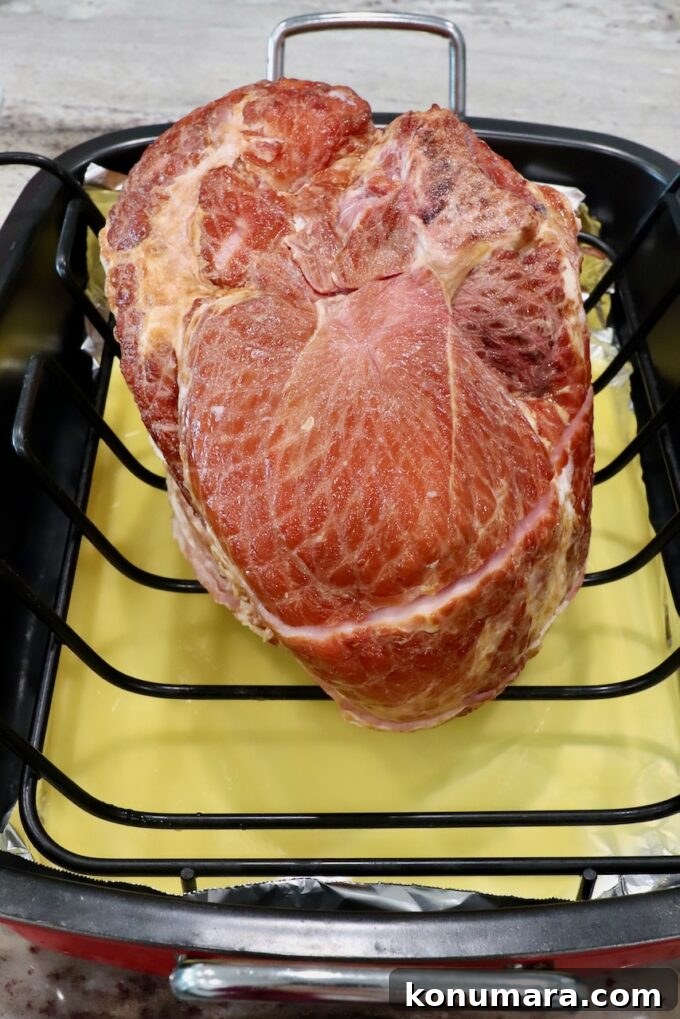 Honey-Baked Ham Recipe with Brown Sugar Glaze 4 spiral ham in roasting pan with pineapple juice
