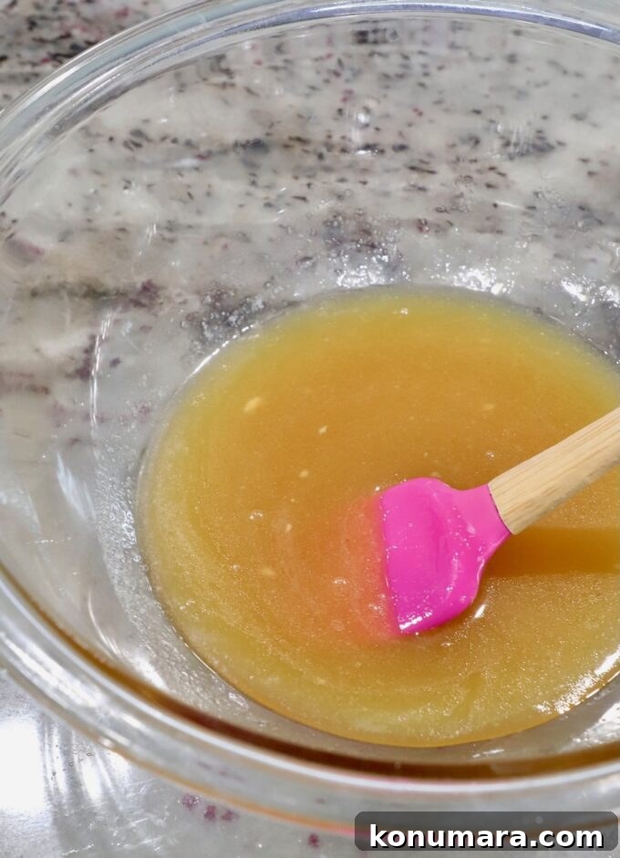 Honey-Baked Ham Recipe with Brown Sugar Glaze 5 honey glaze in bowl with pink spatula