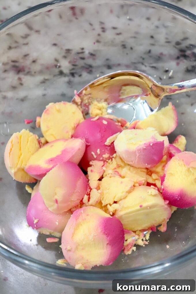 Vibrant Beet Deviled Eggs Recipe with Herbed Filling 6 the yolks from beet-pickled hard boiled eggs in a glass bowl with spoon