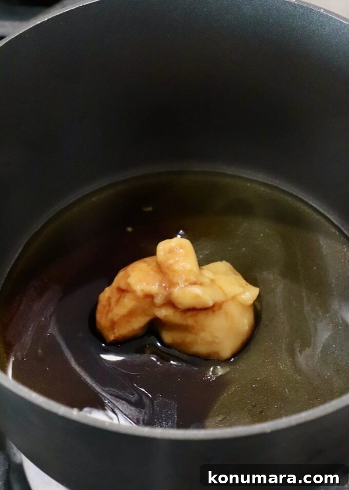 miso paste in a small pot on the stove with sesame oil, honey, mirin and soy sauce