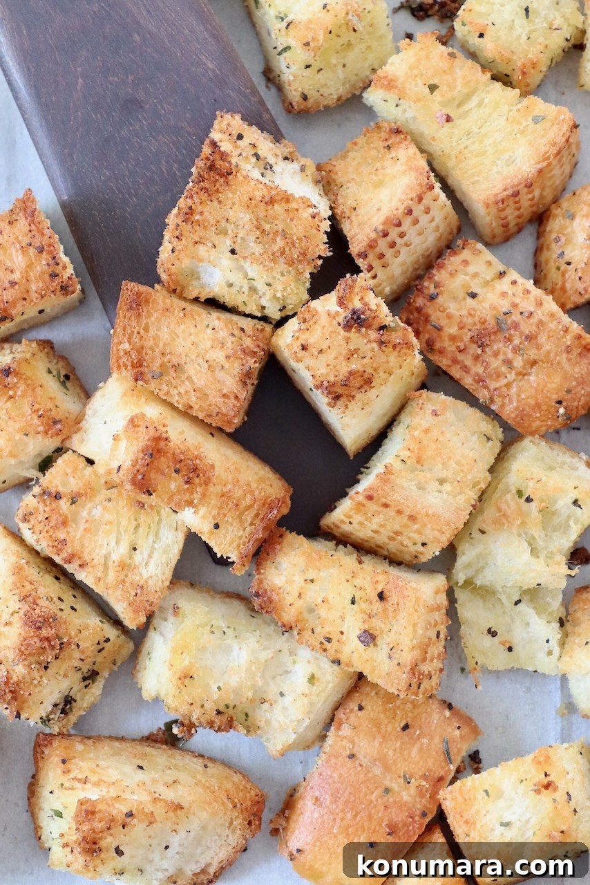 How to Make Crispy Homemade Croutons 5 croutons on baking sheet with spatula