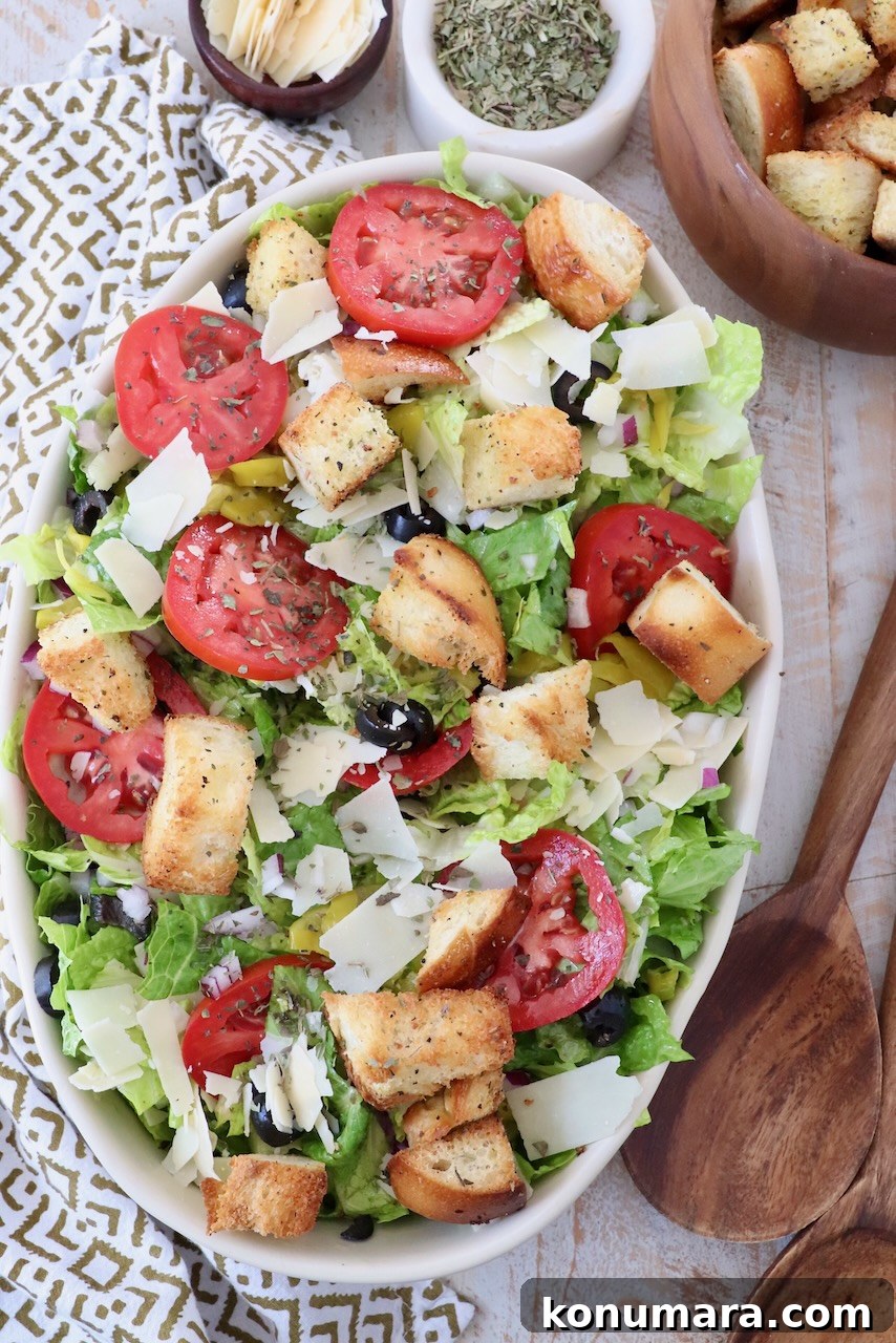Italian Salad Recipe with Fresh Mozzarella and Herbs 5 salad in serving dish topped with croutons and sliced tomatoes