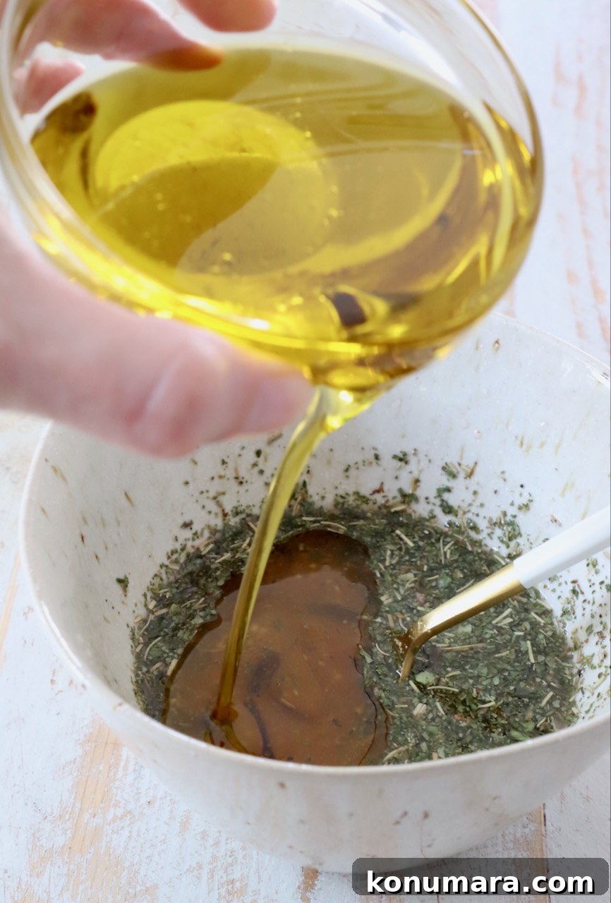 Homemade Zesty Italian Dressing for Salads 4 oil poured into bowl with vinegar and herbs