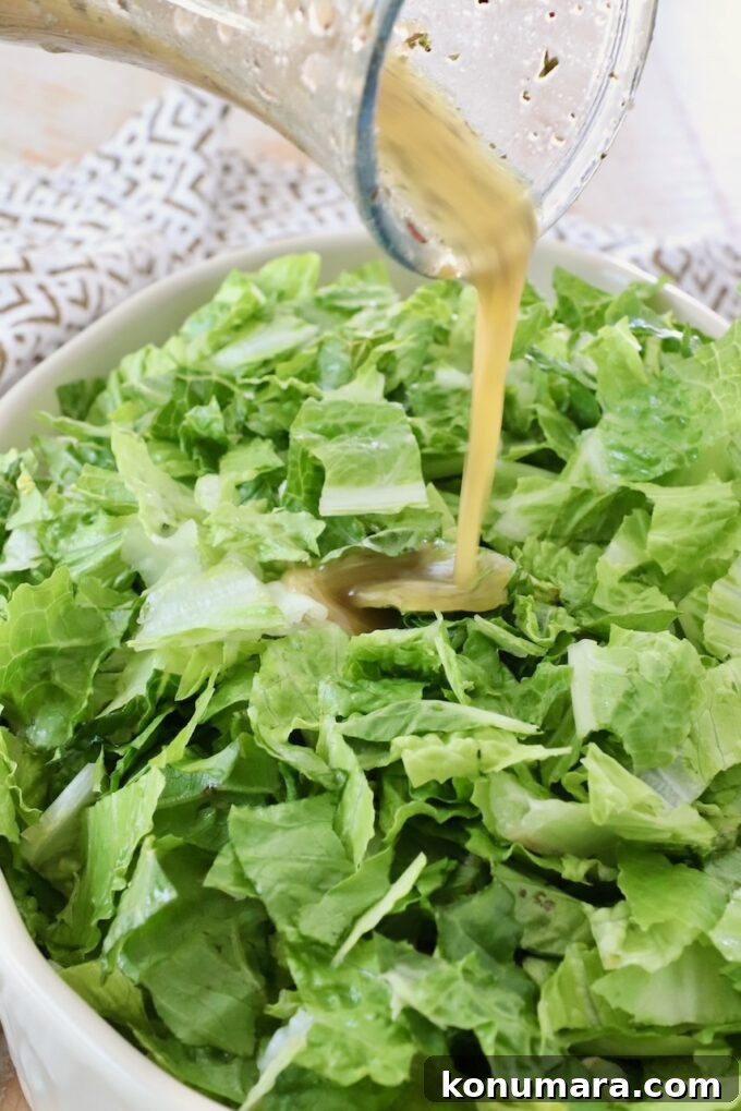 Homemade Zesty Italian Dressing for Salads 5 salad dressing poured onto a bowl of chopped greens