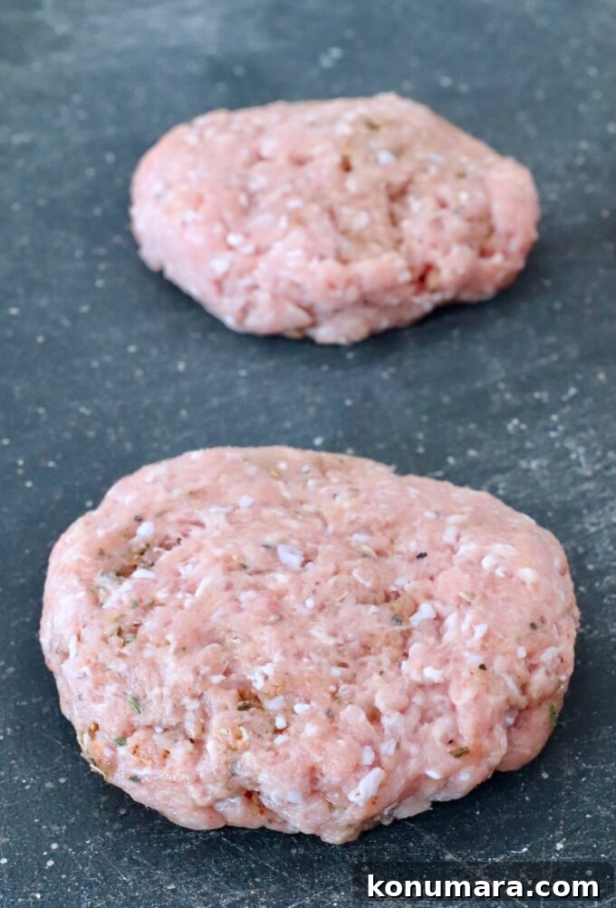 Juicy Turkey Burger Recipe with Savory Seasoning 5 uncooked turkey burger patties on cutting board