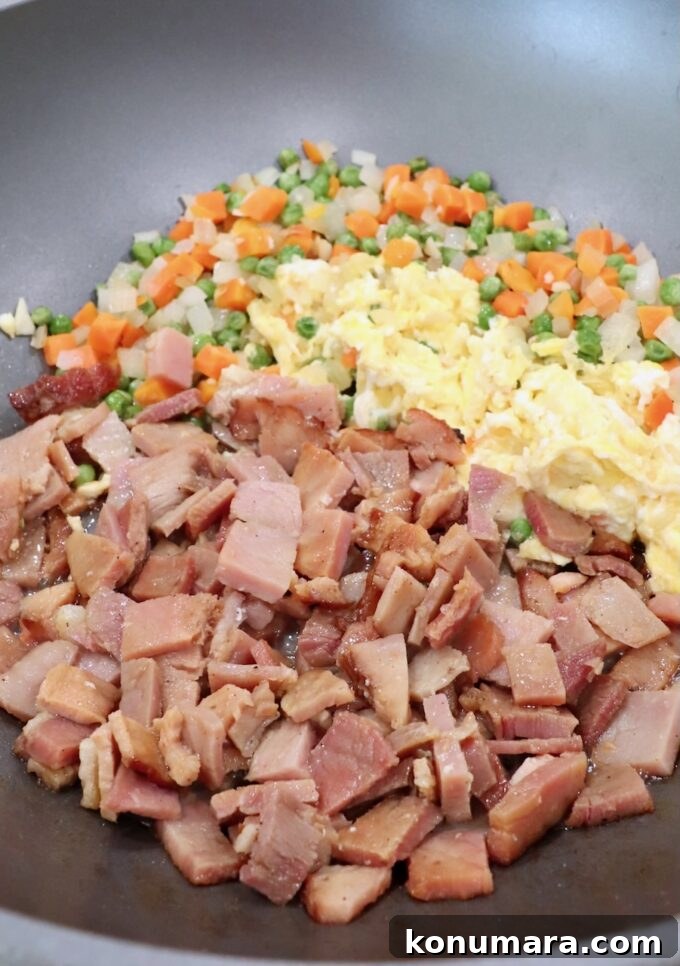 Classic Ham Fried Rice Recipe with Eggs and Peas 6 diced ham in skillet with scrambled eggs and veggies