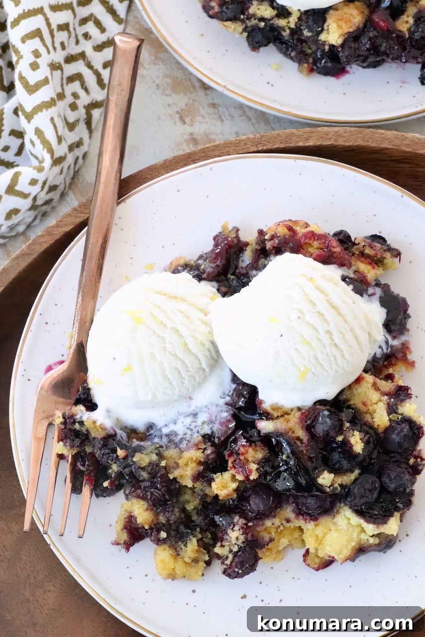 How to Make Homemade Blueberry Pie Filling 8 blueberry dump cake on plate with fork, topped with scoops of vanilla ice cream