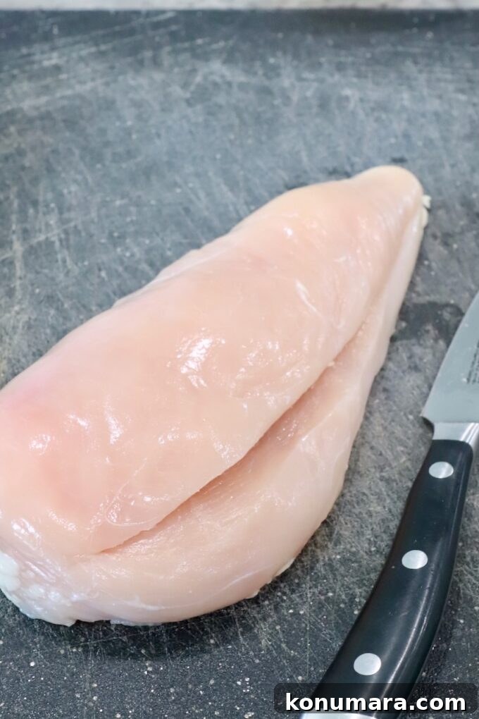 chicken breast sliced in the middle on cutting board