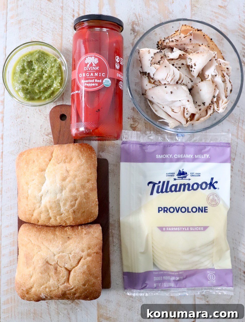 Grilled Turkey Pesto Sandwich with Melted Mozzarella 3 ingredients for turkey pesto sandwiches on white wood board