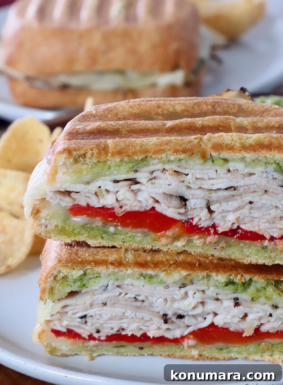 Grilled Turkey Pesto Sandwich with Melted Mozzarella 9 turkey panini sliced in half and stacked up on plate