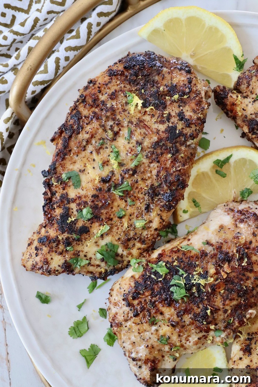 Crispy Lemon Pepper Chicken Recipe with Garlic Butter 11 lemon pepper chicken on plate with sliced lemons