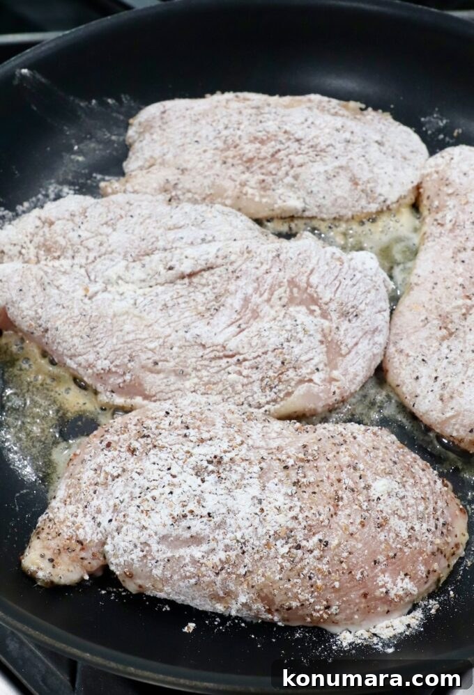Crispy Lemon Pepper Chicken Recipe with Garlic Butter 6 seasoned chicken breasts cooking in butter in skillet