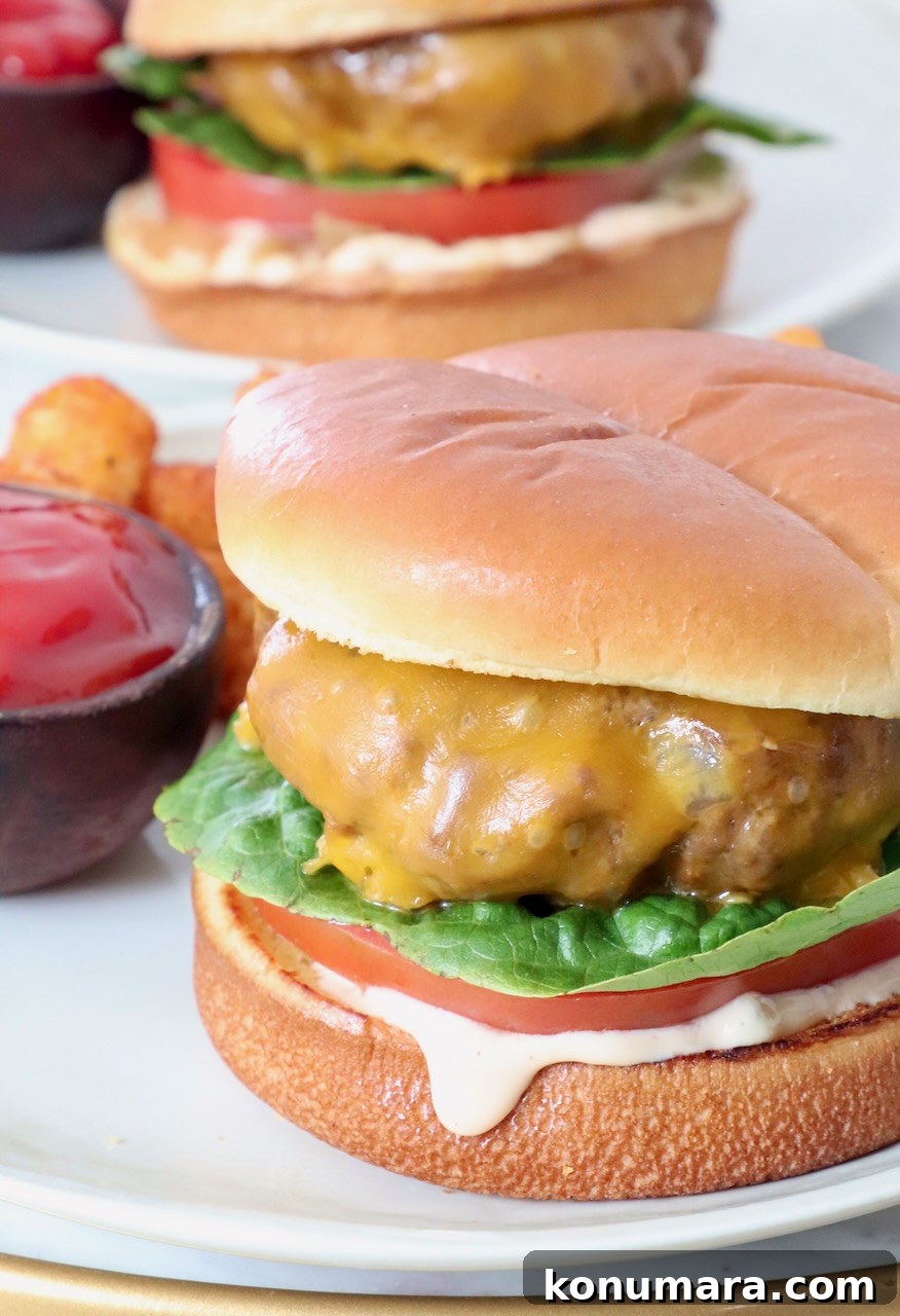 cooked cheeseburger on plate with a side small bowl of ketchup