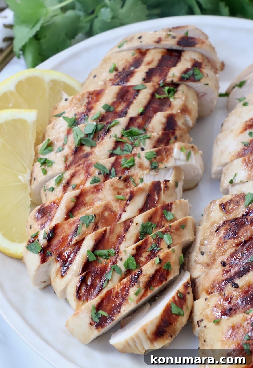Garlic Lemon Chicken Marinade for Juicy Grilled Chicken 2 sliced grilled chicken on plate with lemon wedges