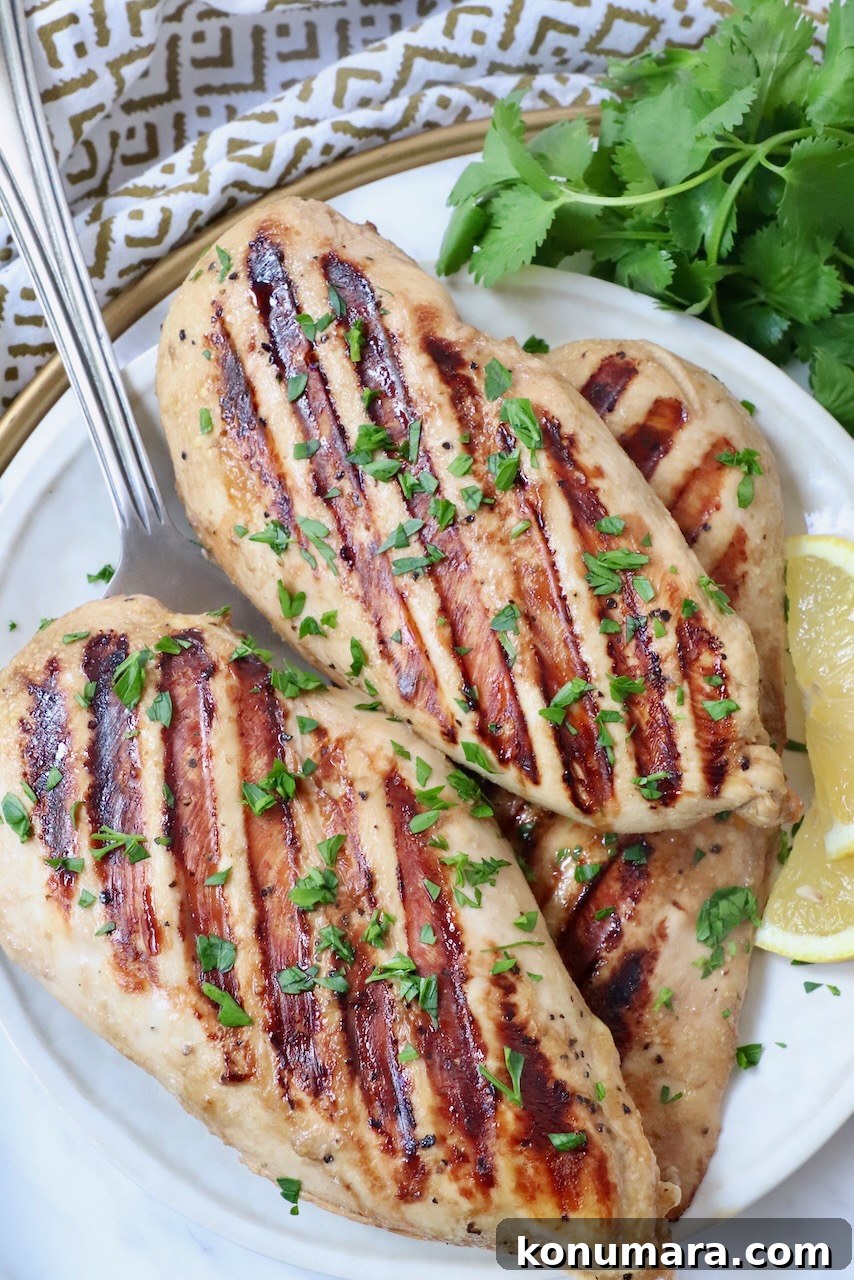 Garlic Lemon Chicken Marinade for Juicy Grilled Chicken 5 grilled chicken breasts on plate with lemon wedges