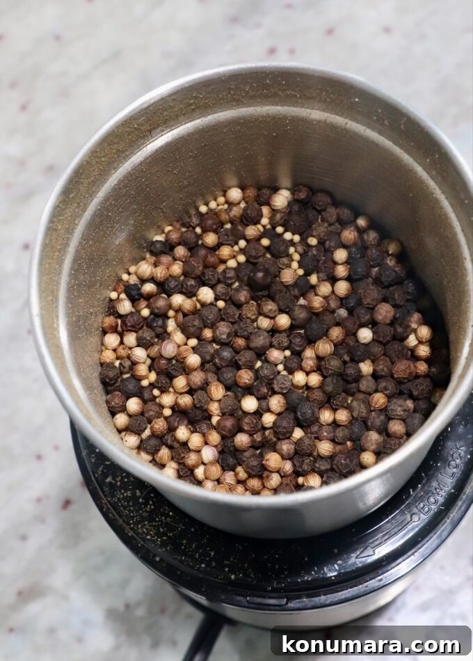 peppercorns, coriander seeds and mustard seeds in spice grinder