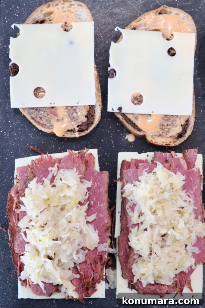 Classic New York Pastrami Sandwich Recipe 5 swiss cheese, sliced pastrami and sauerkraut on slices of rye bread on cutting board
